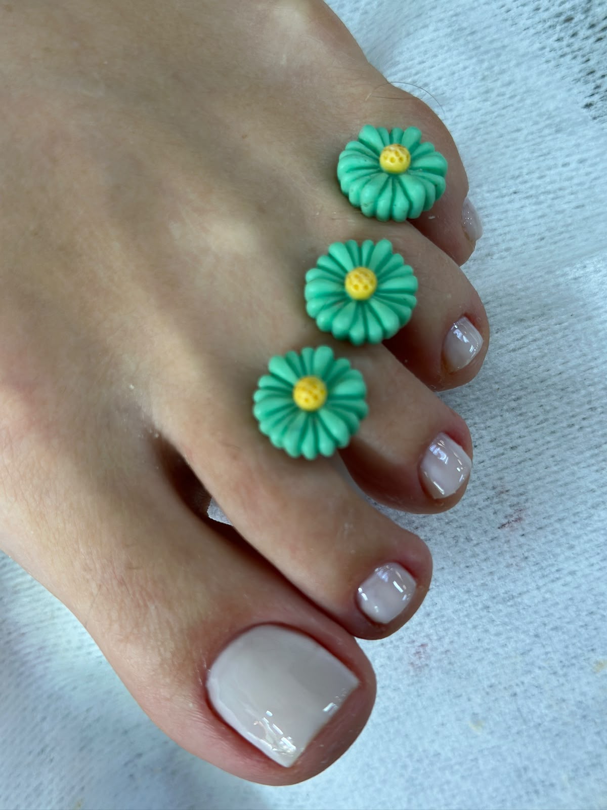 Pedicure nude com separadores florais